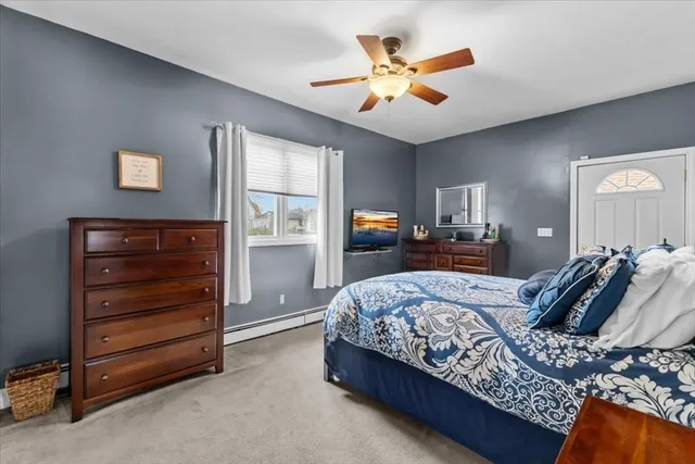 a bedroom with a bed a dresser and a chandelier