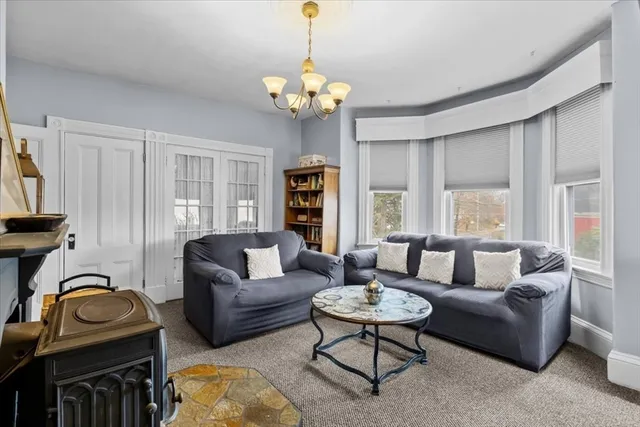 a living room with furniture a chandelier and a window