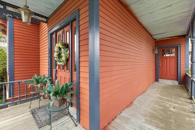 a view of a porch with a potted plant and floor to ceiling window