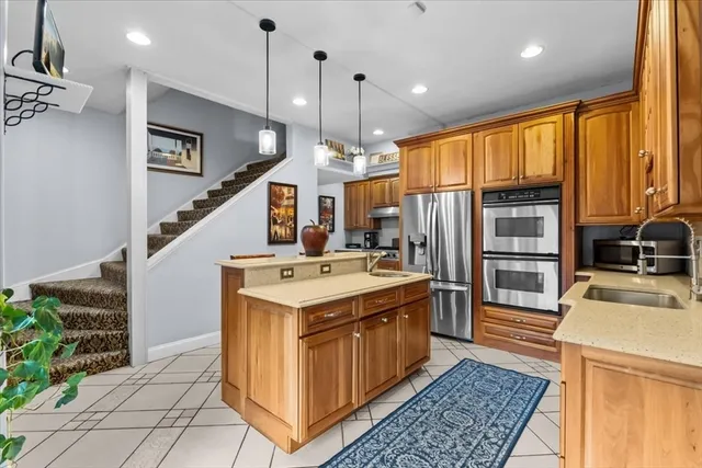 a kitchen with kitchen island granite countertop a sink stove and refrigerator