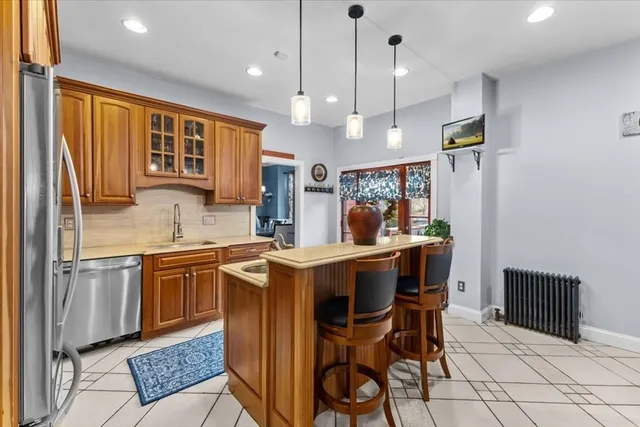 a kitchen with stainless steel appliances granite countertop a sink a stove a refrigerator and island