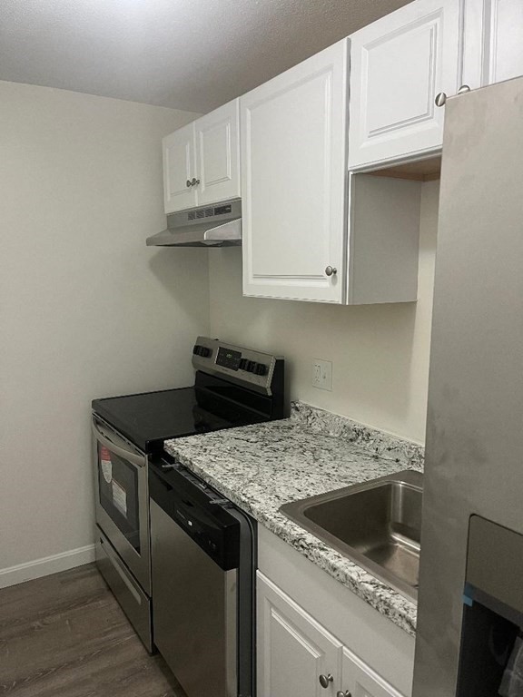800 County Street, Unit 20 Taunton, MA 02780 - Photo 4 of 19 a kitchen with granite countertop white cabinets and a stove