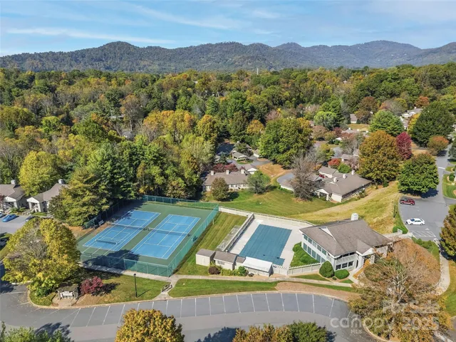 a view of a brick house with a large windows stairs and potted plants