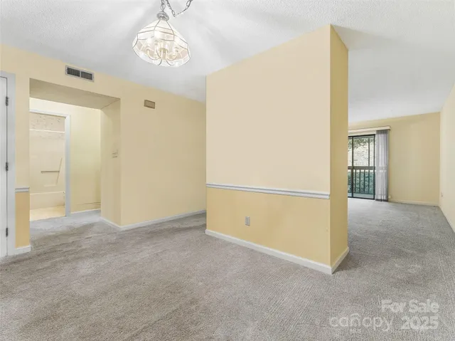 an empty room with chandelier fan