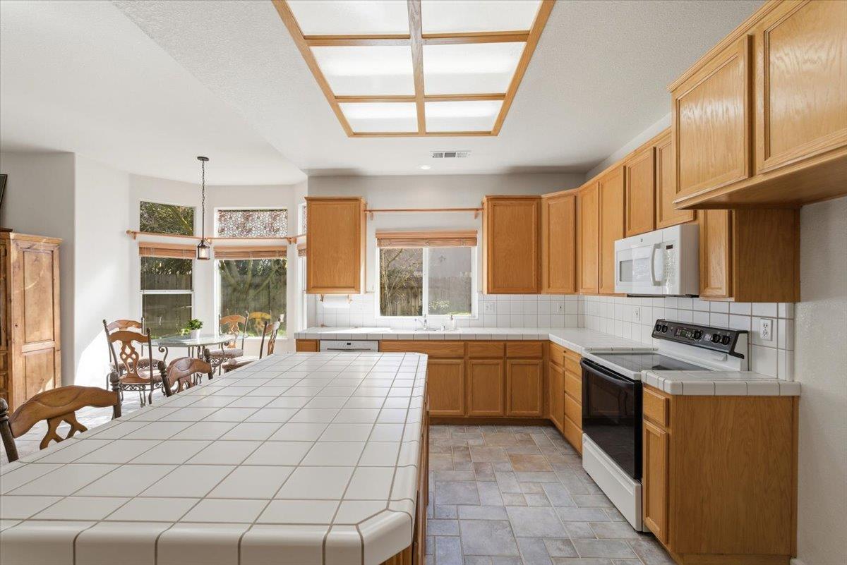1903 Alex Way Turlock, CA 95382 - Photo 11 of 40 a kitchen with stainless steel appliances granite countertop a stove a sink and a refrigerator