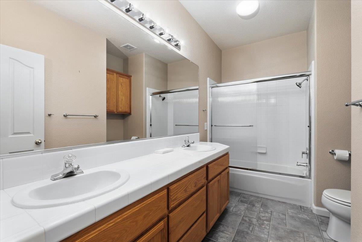 1903 Alex Way Turlock, CA 95382 - Photo 26 of 40 a bathroom with a sink double vanity granite toilet and shower