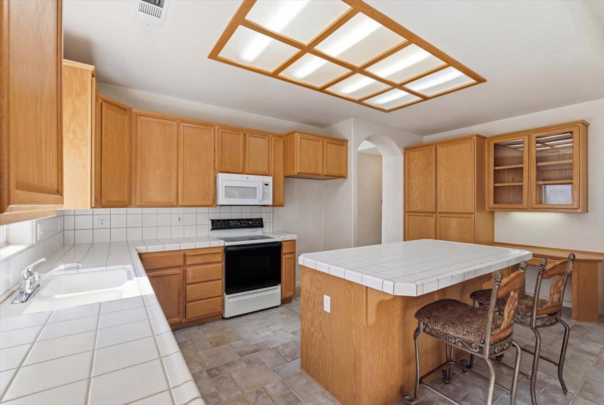 1903 Alex Way Turlock, CA 95382 - Photo 10 of 40 a kitchen with stainless steel appliances granite countertop a stove a sink dishwasher and a refrigerator with wooden cabinets