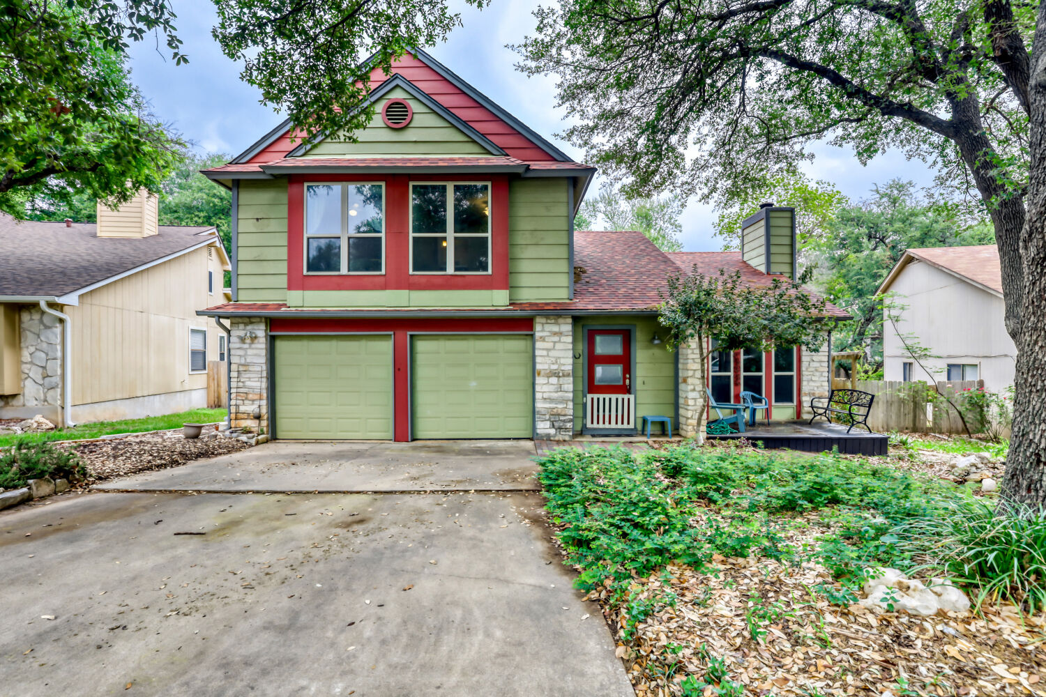 Craftsman-style home featuring stone siding, concrete driveway, a garage, and a chimney