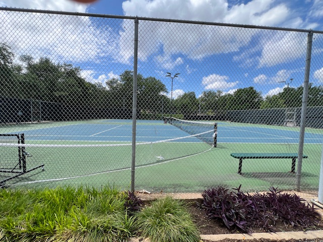 13129 New Boston Bend Austin, TX 78729 - Photo 26 of 26 This property features a tennis court with a green and blue surface, enclosed by a chain-link fence