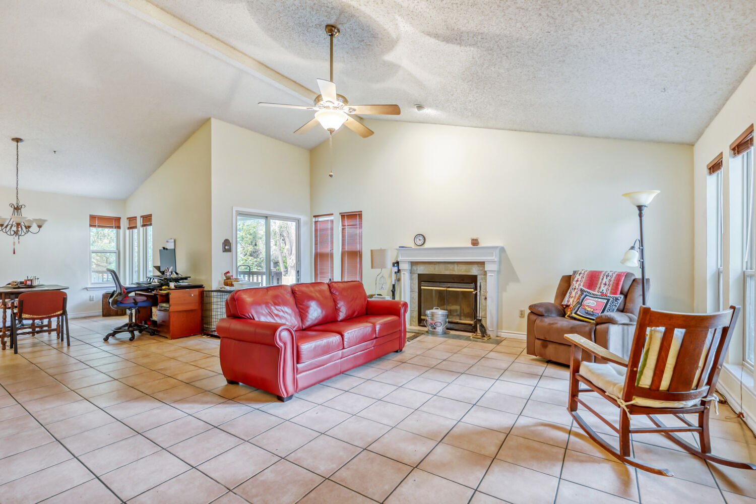 13129 New Boston Bend Austin, TX 78729 - Photo 3 of 26 Living area featuring light tile patterned floors, a fireplace, a Vaulted ceiling