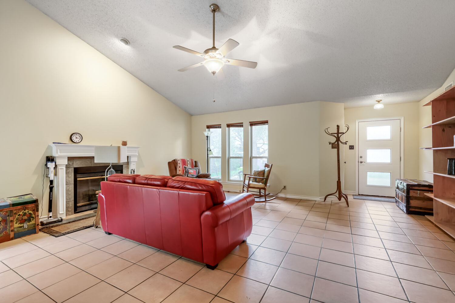 13129 New Boston Bend Austin, TX 78729 - Photo 5 of 26 Living area with a ceiling fan, a glass covered fireplace, and light tile patterned floors