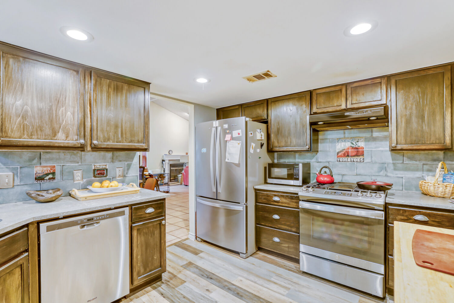 13129 New Boston Bend Austin, TX 78729 - Photo 6 of 26 Kitchen featuring stainless steel appliances, wood finish cabinetry, decorative backsplash, light wood-style flooring, and recessed lighting