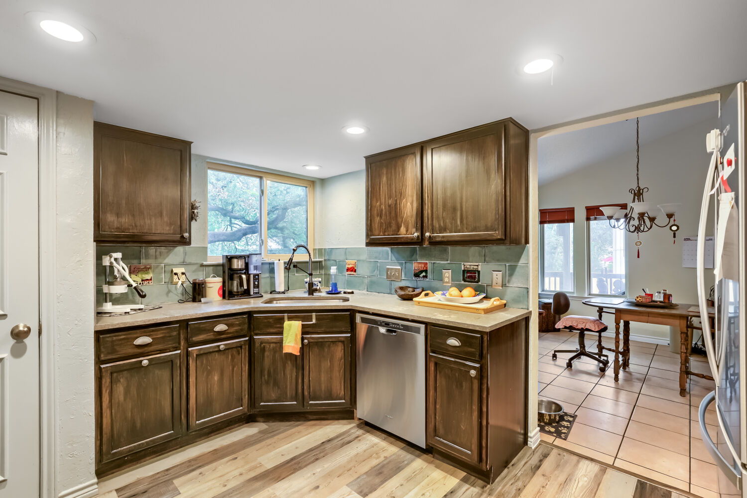 13129 New Boston Bend Austin, TX 78729 - Photo 7 of 26 Kitchen with tasteful backsplash, dark wood finish cabinetry, stainless steel appliances, light wood-style flooring, and lofted ceiling