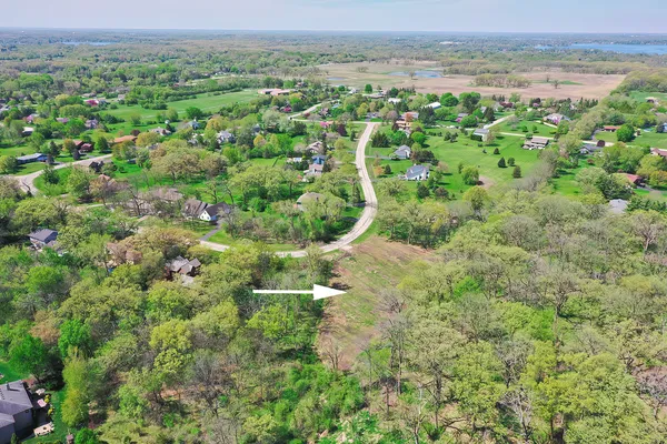 an aerial view of residential houses with outdoor space and trees