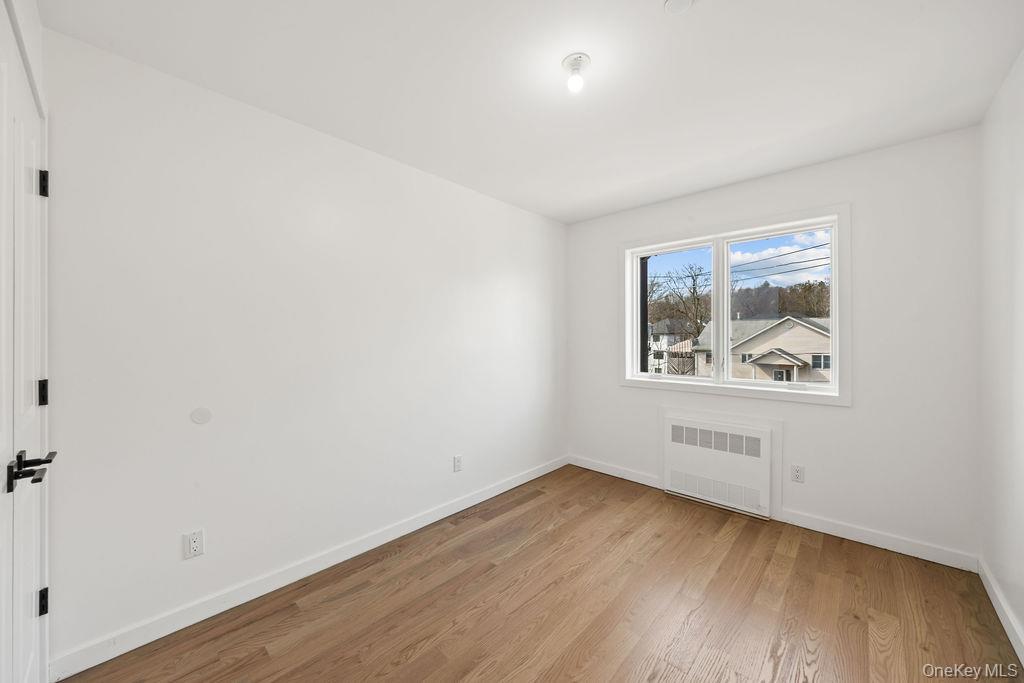62 Blauvelt Road, Unit 202 Monsey, NY 10952 - Photo 26 of 34 an empty room with wooden floor and window