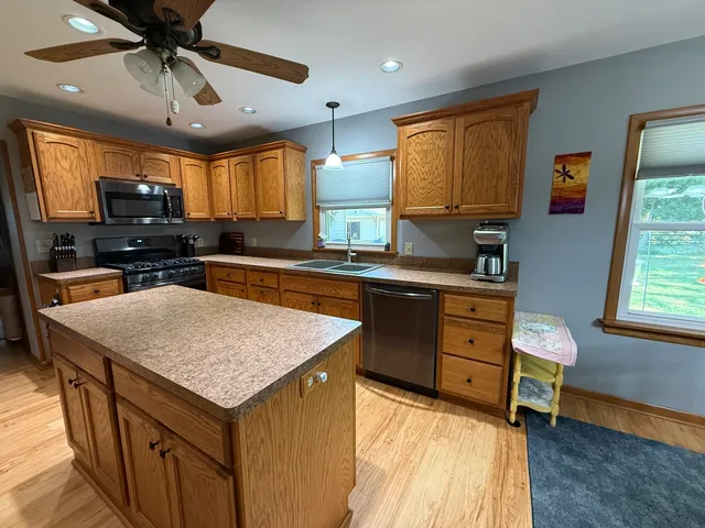 a kitchen with a stove a sink a counter space and a window