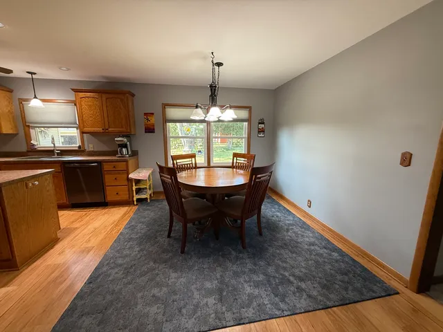 a dining room with furniture a chandelier and wooden floor