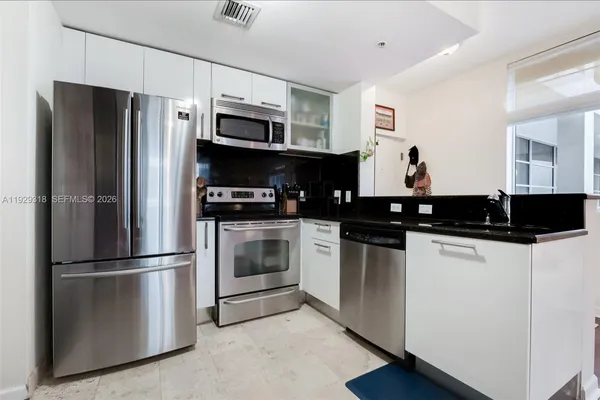 a kitchen with stainless steel appliances and refrigerator