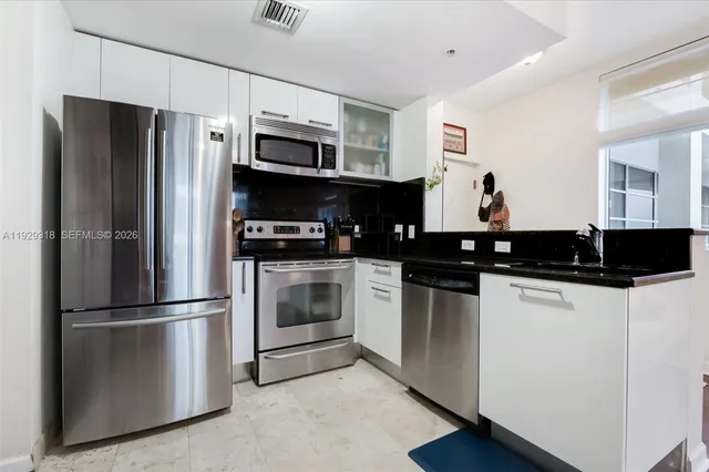 a kitchen with stainless steel appliances and refrigerator