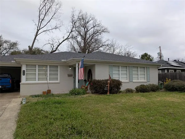 a front view of a house with a garden and plants