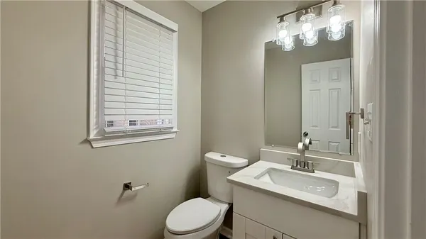 a bathroom with a toilet a sink and mirror