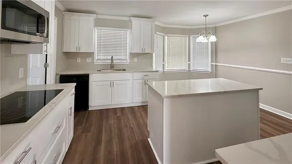 a kitchen with stainless steel appliances granite countertop a sink and a stove
