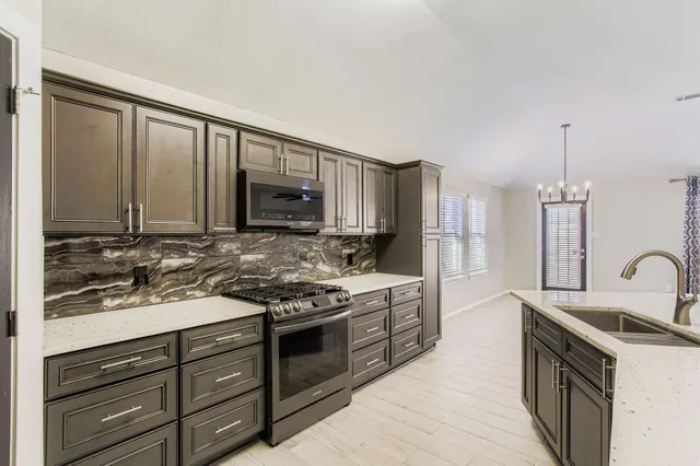a kitchen with stainless steel appliances granite countertop a stove and a sink