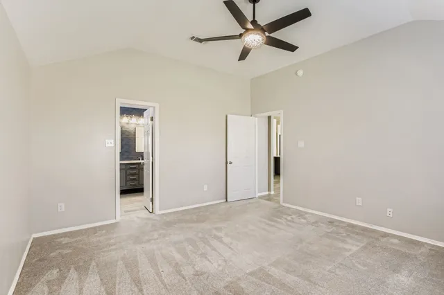 an empty room with closet and a ceiling fan