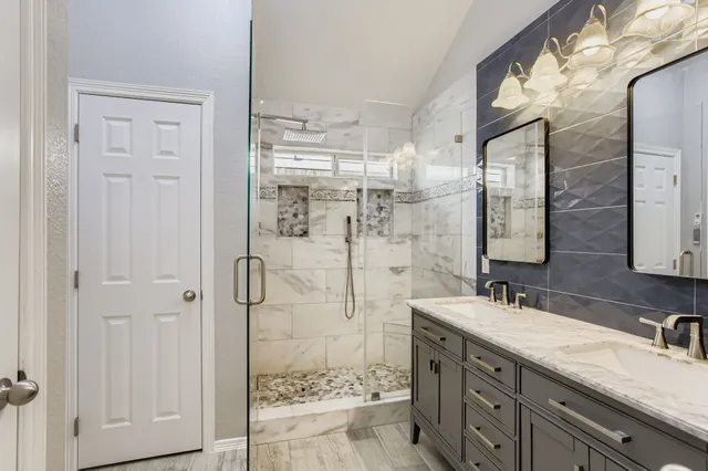 a bathroom with a granite countertop shower sink and mirror