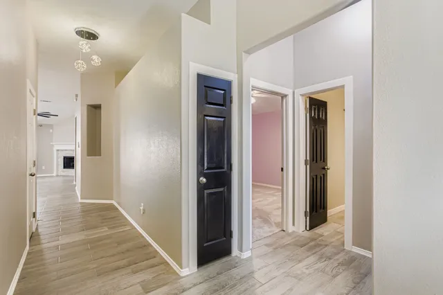 a view of a hallway with wooden floor and a bathroom
