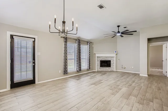 a view of an empty room with a fireplace and a window