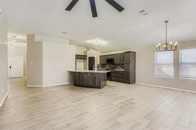 a large kitchen with stainless steel appliances a refrigerator and a sink