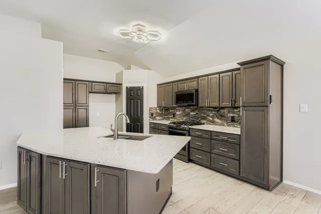 a kitchen with stainless steel appliances a sink and a refrigerator
