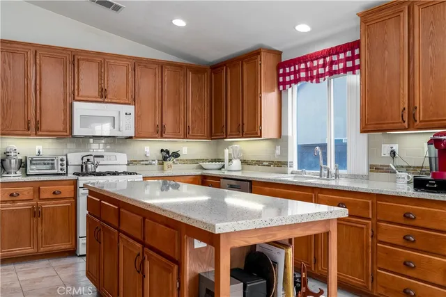 a kitchen with stainless steel appliances granite countertop a sink and a table