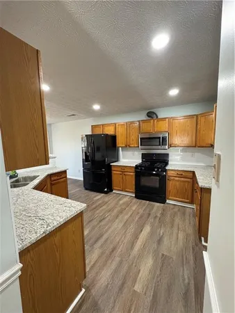 a kitchen with stainless steel appliances kitchen island granite countertop a stove and a sink