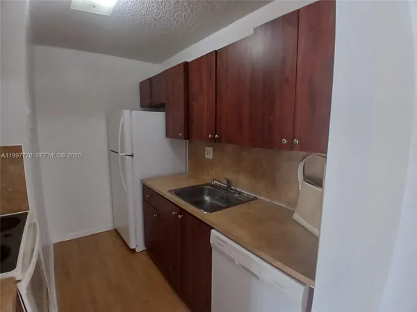 a kitchen with a refrigerator and a stove top oven