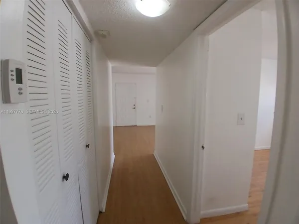 a view of a hallway with wooden cabinets