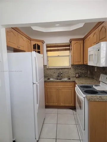 a kitchen with a refrigerator sink and stove