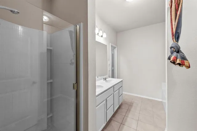 a bathroom with a double vanity sink a mirror and a bathtub