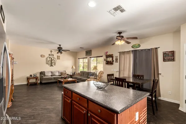 a living room with kitchen island furniture a chandelier a sink and a window