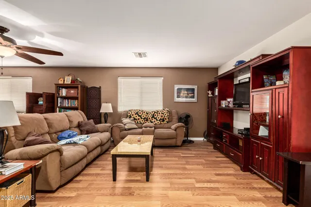 a living room with furniture a lamp and a flat screen tv
