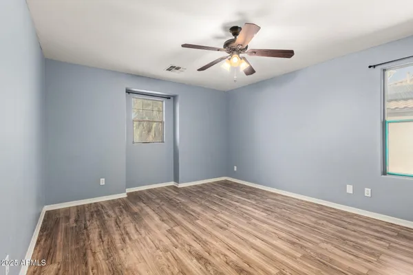 a view of a big room with wooden floor and windows
