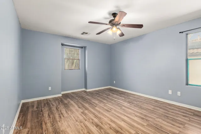 a view of a big room with wooden floor and windows
