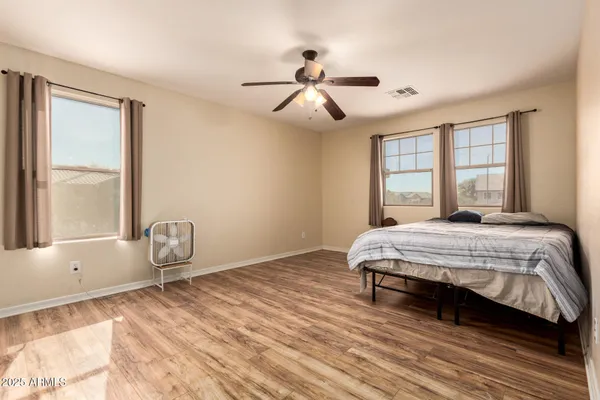 a bedroom with a bed wooden floor and window