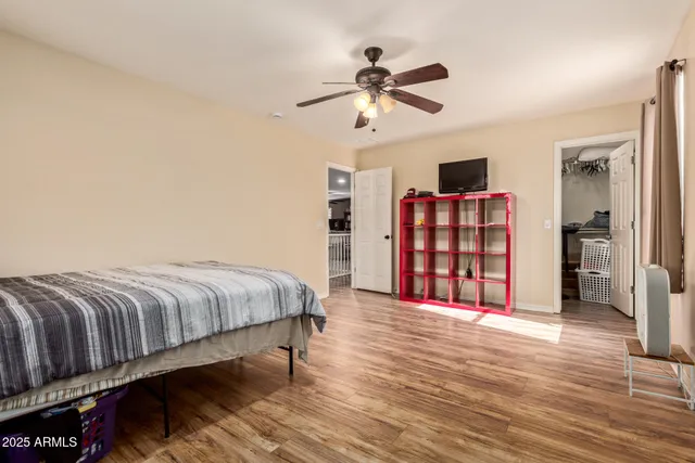 a spacious bedroom with a bed and wooden floor