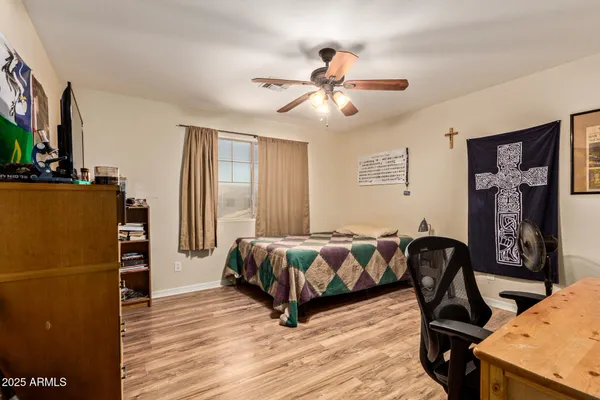 a spacious bedroom with a bed and wooden floor