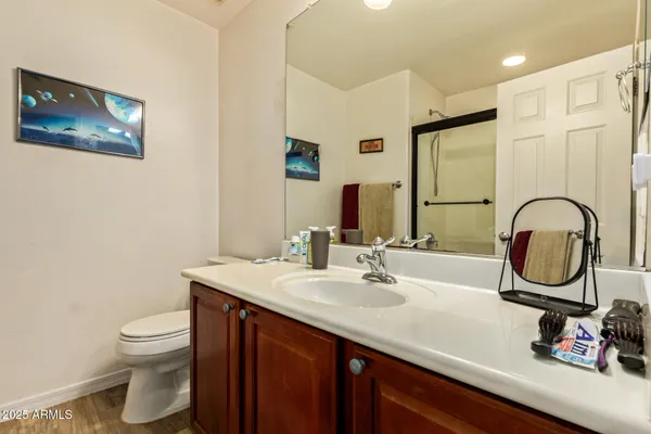 a bathroom with a granite countertop sink a mirror and a shower