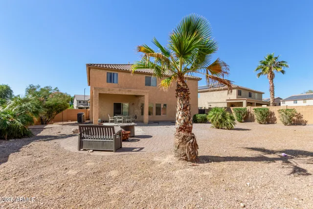 a view of a house with backyard and sitting area
