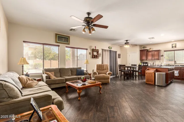 a living room with furniture kitchen view and a large window