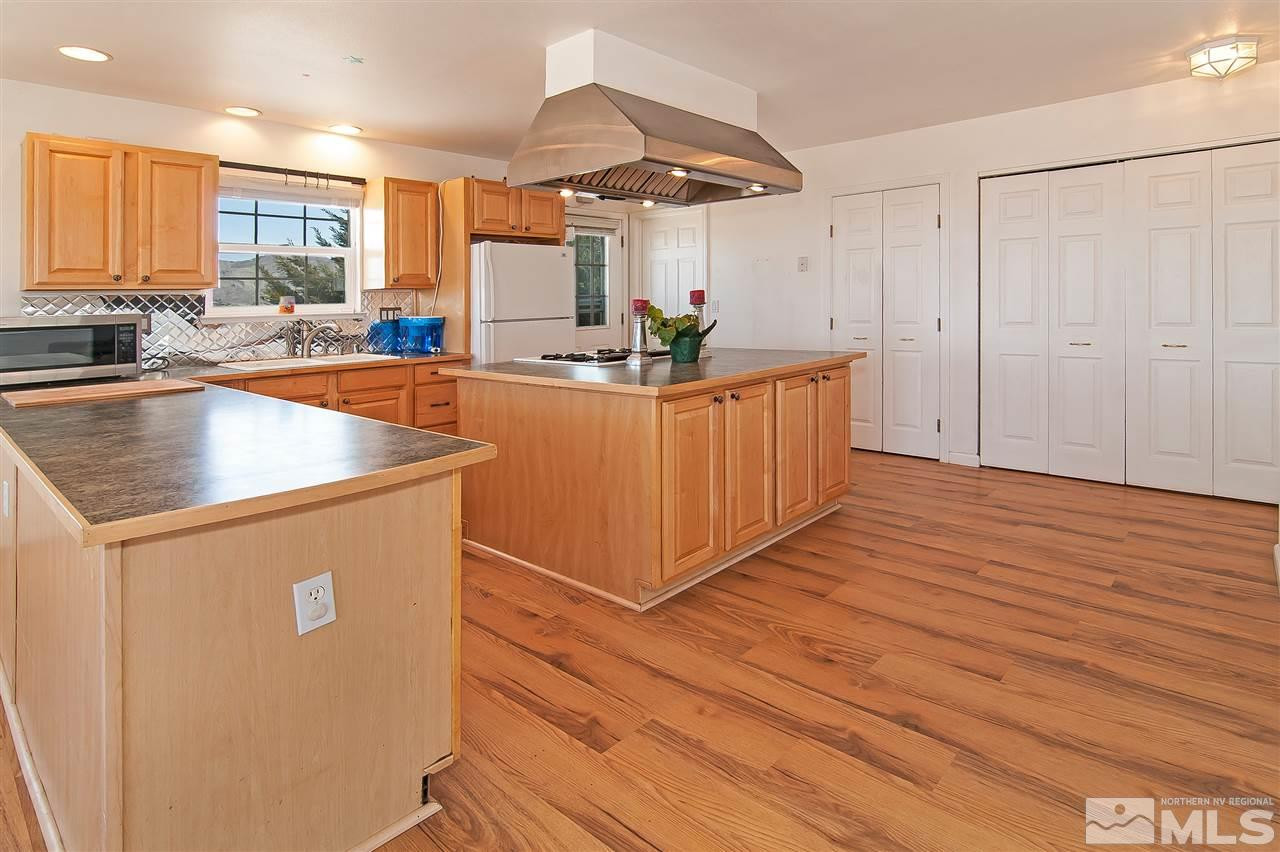 90 Bobcat Hill Road Reno, NV 89508 - Photo 11 of 24 a kitchen with stainless steel appliances granite countertop a sink a stove a refrigerator and island with wooden floor